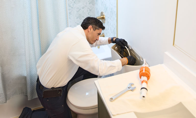 technician fixing toilet